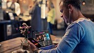 Man using personal devices in a coffee shop to access university software