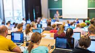 Students using devices to take notes in a lecture